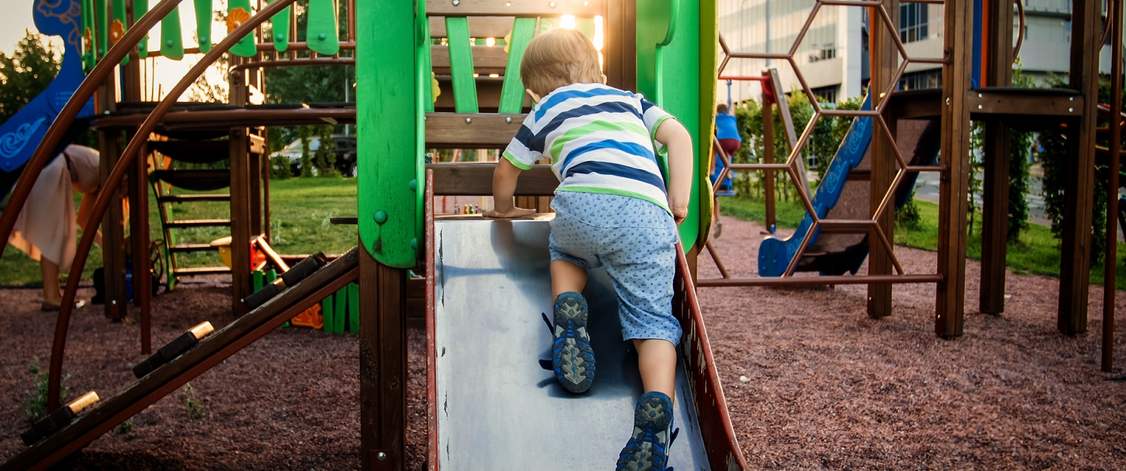 child playing on playground slide
